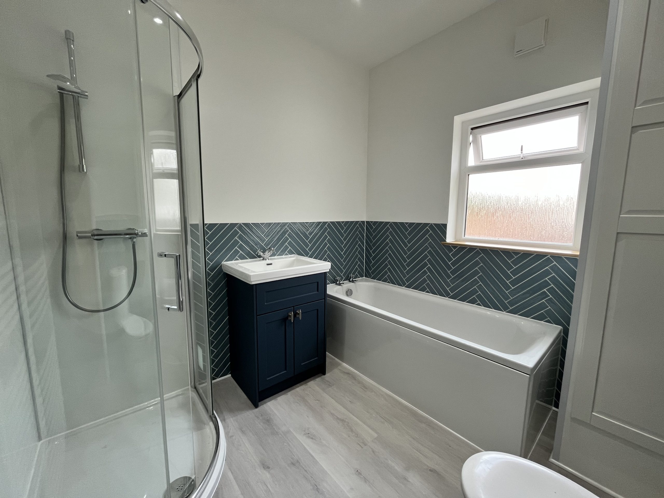 Completed blue herringbone bathroom installation in Leeds
